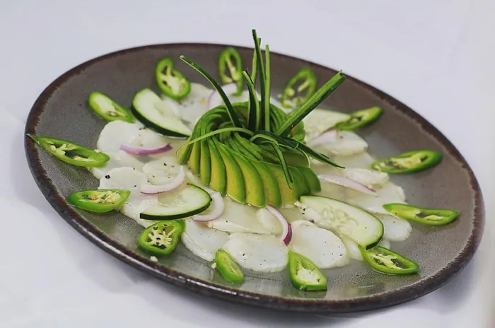 Aguachile con rodajas de pepino, cebolla morada, chile serrano y aguacate